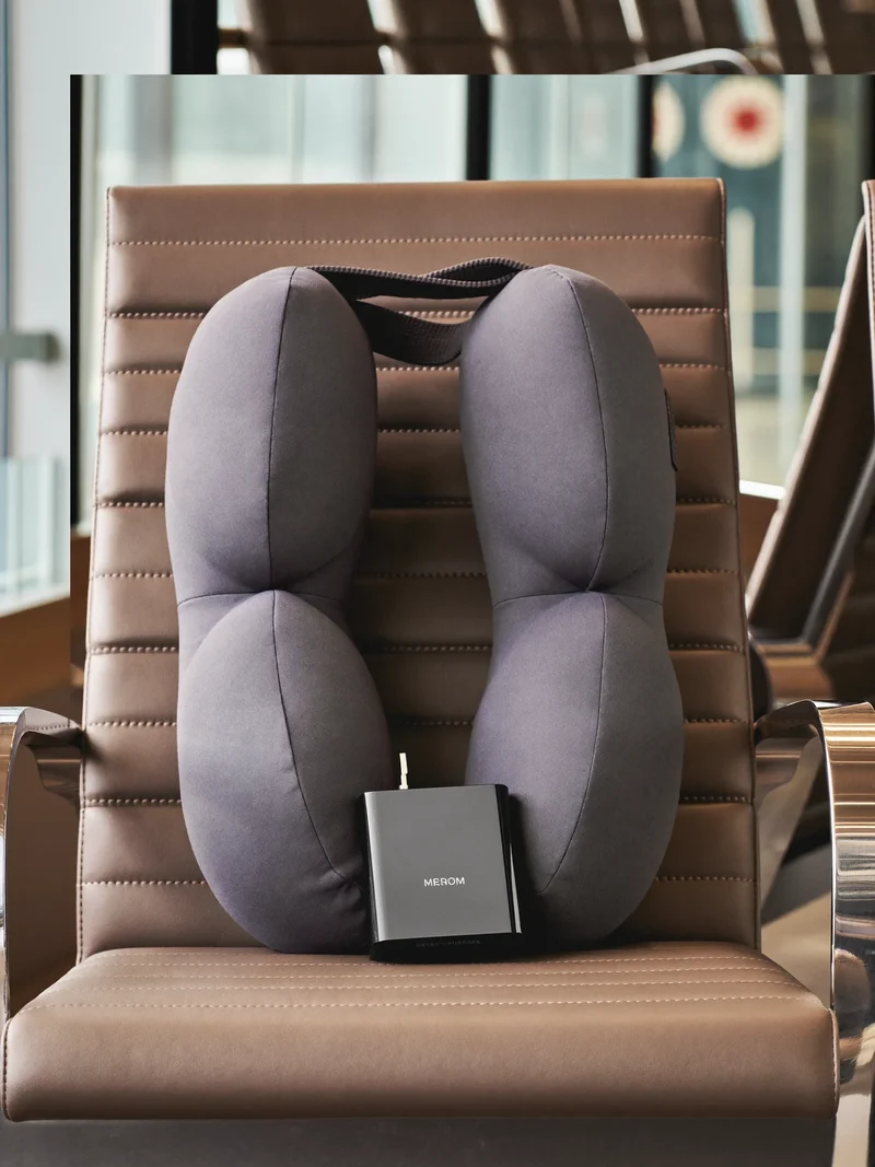 Nackenkissen aus Memory-Schaum mit Reiseadapter auf einem Sitz in der Flughafenlounge